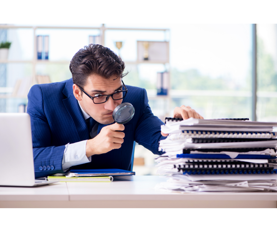 Hombre buscando información con lupa.